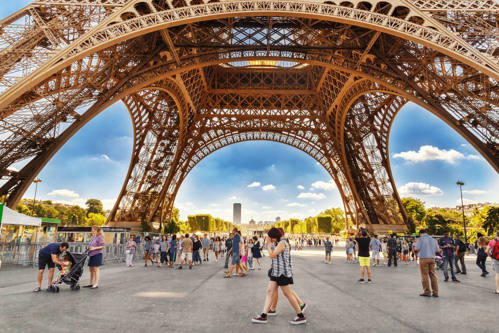 Touristes marchant sous la Tour Eiffel